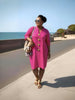 Hot-pink midi dress with long sleeves, button front, and round neckline.