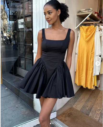 Black pleated skater dress with square neckline and gathered flared skirt