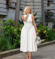 White pleated midi A-line dress, sleeveless high neckline, fitted waist to skirt