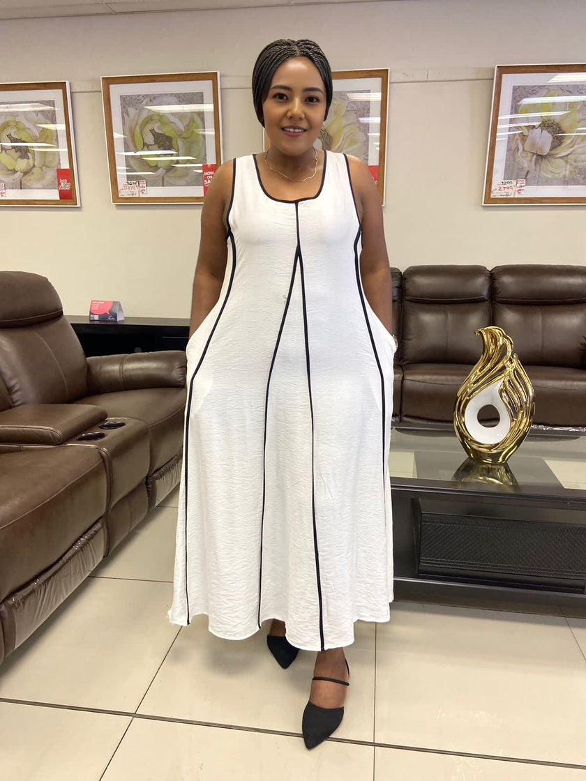 White sleeveless A-line maxi dress with black trim and full-length skirt