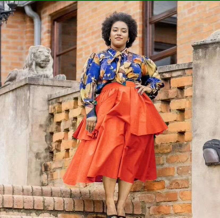 Floral puff-sleeve blouse with neck bow, paired with orange-red tiered skirt