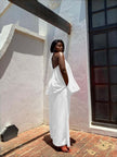 White sleeveless twin set top and wide-leg pants, draped open-back design