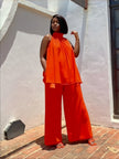 Orange-red sleeveless twin set top and wide-leg pants, layered ruffle hem
