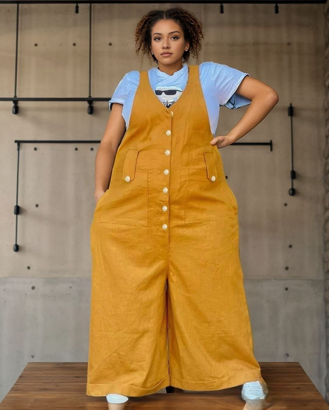 Yellow loose jumpsuit with adjustable bib straps, front buttons, and wide legs