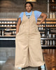 Beige loose jumpsuit with center buttons, chest pockets, and wide legs