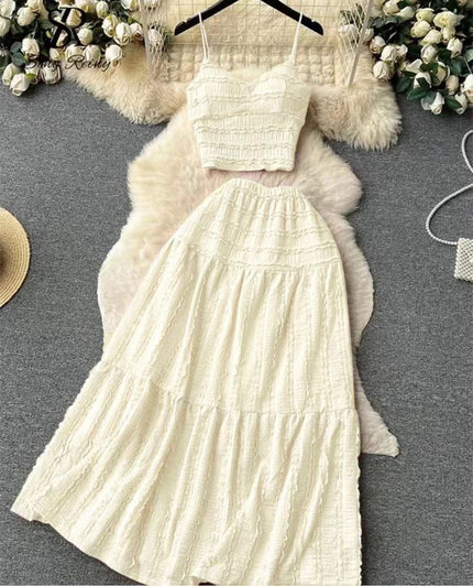 Cream pleated maxi skirt with elastic waistband; matching cropped cami top