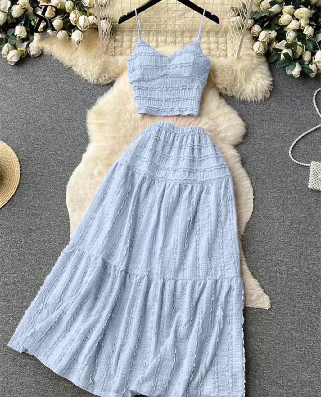 Light-blue pleated maxi skirt with elastic waistband and tiered ruffle texture