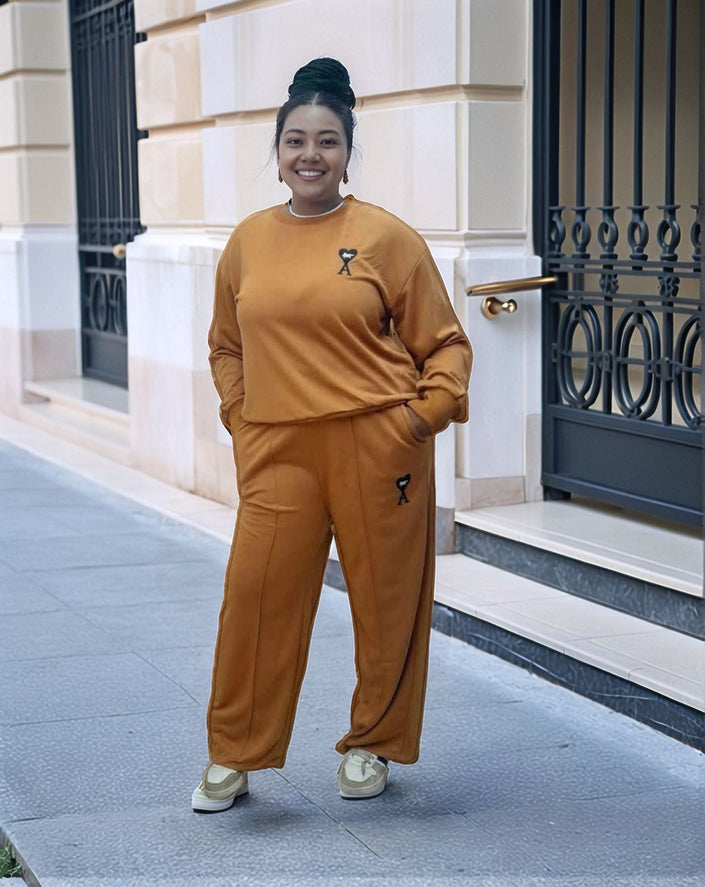 Orange-red two-piece jogger set with crewneck sweatshirt and embroidered leg logo