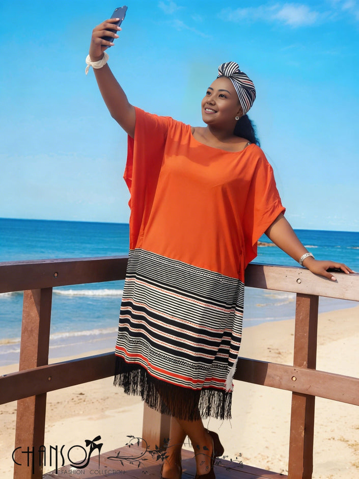 Orange-red midi dress with wide sleeves, striped skirt panels and fringed hem