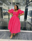 Deep-pink midi dress with puff sleeves, square neckline, floral applique at waist.