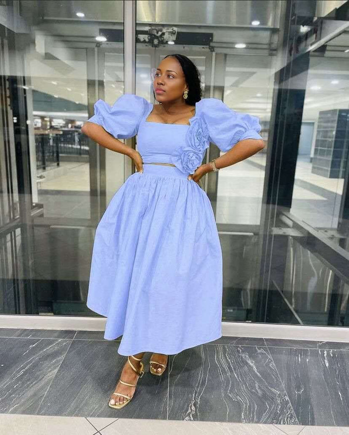 Sky-blue midi dress with puff sleeves, square neckline, floral applique at waist.