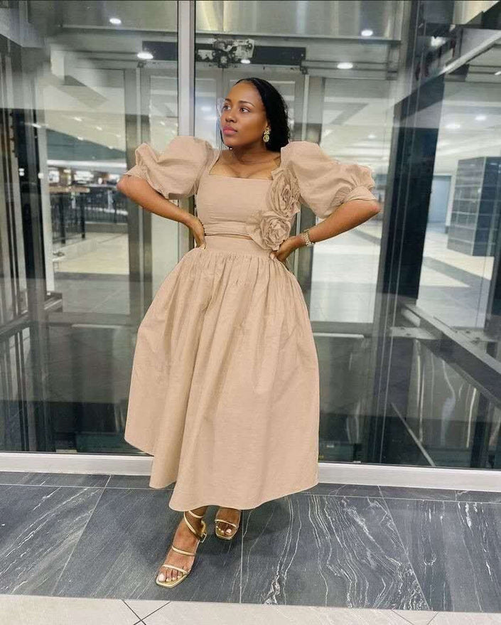 Tan midi dress with puff sleeves, square neckline, floral applique at waist.