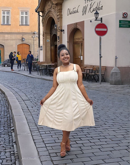 Cream sleeveless pleated midi dress with square neckline and flared skirt