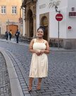 Cream pleated midi dress with sleeveless bodice, square neckline and gathered skirt