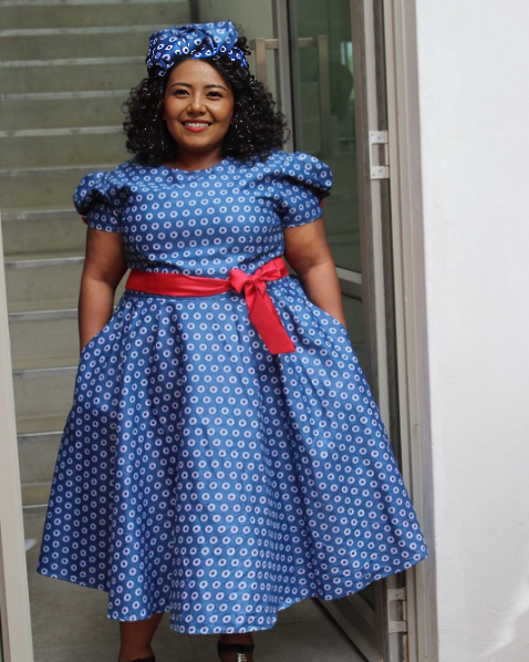 Blue polka dot puff sleeve dress with red waist tie and full skirt