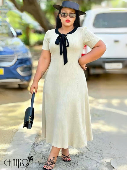 Ribbed A-line midi dress with black bow-tie neckline and short sleeves, cream knit