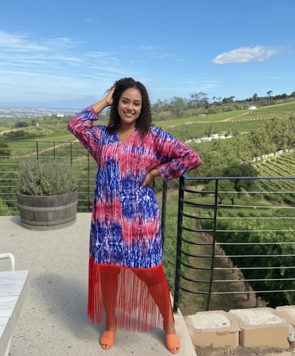 Tie-dye maxi dress with V-neck, long sleeves, and red fringe hem