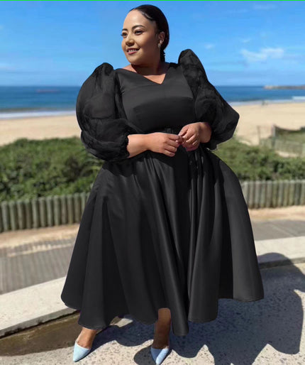 Black satin midi dress with dramatic puff sleeves and waist belt, gathered skirt