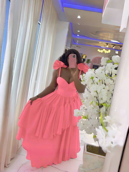 Pink evening dress with layered ruffles, puffy shoulders, and bow spaghetti straps.