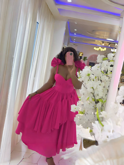 Deep-pink evening dress with layered ruffles, puffy shoulders, and bow spaghetti straps.