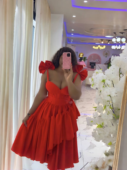 Red evening dress with layered ruffles, puffy shoulders, and bow spaghetti straps.