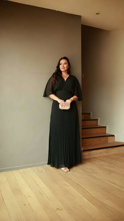 Black pleated maxi dress with V-neck and batwing sleeves, flowing ankle-length skirt