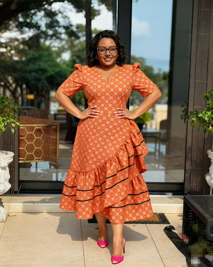Ruffled high-low dress in orange-red with dotted print, V-neck and black-trim tiered hem