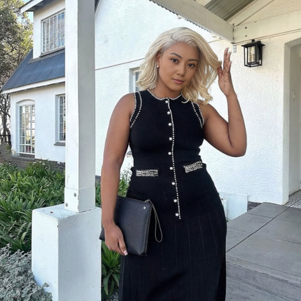 Black sleeveless knitted midi dress with vertical button detail and front patch pockets