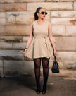 Beige sleeveless mini dress with gold button detailing and V-neck