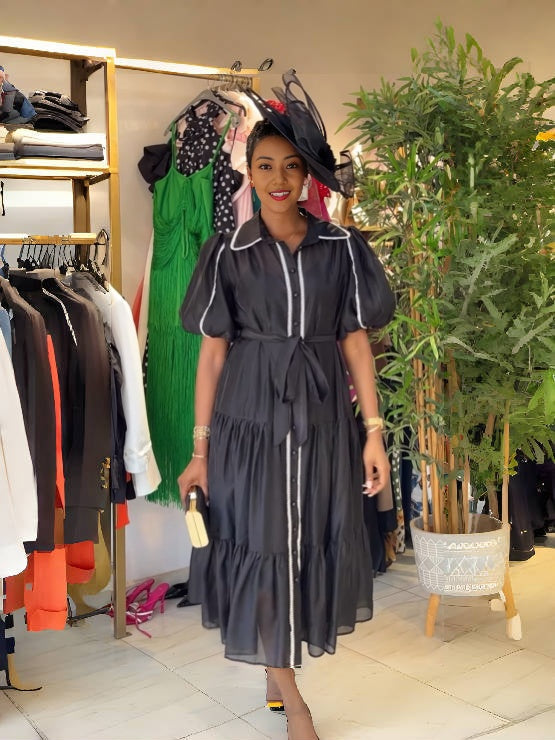 Black tiered puff-sleeve dress with white piping, button front, and gathered skirt