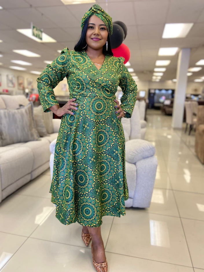 A-line midi dress in green with geometric African print, V-neck and long sleeves.