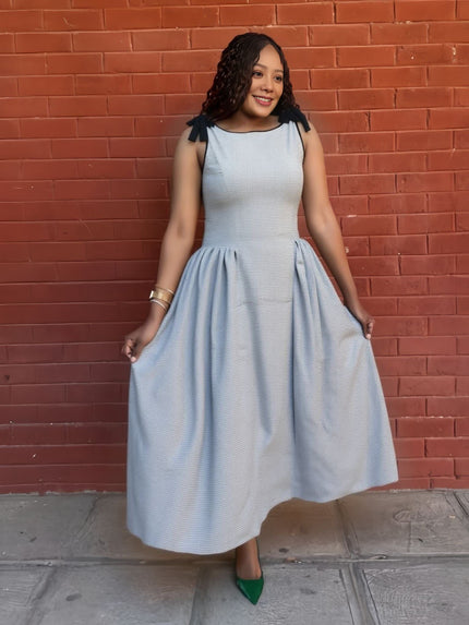 Light blue pleated midi dress with bow shoulder straps and round neckline