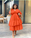 Orange-red tiered midi dress with puff sleeves and V-neck, gathered waist