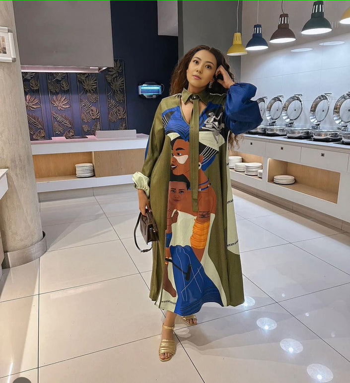 Printed long-sleeve maxi dress with multicolor African-style figures on green fabric