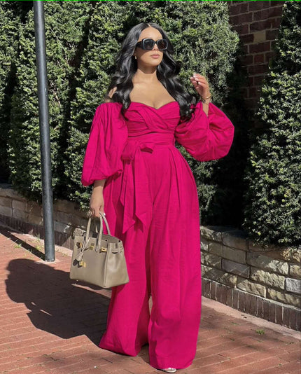 Deep-pink off-shoulder jumpsuit with puff sleeves, ruched bodice, and wide-leg pants