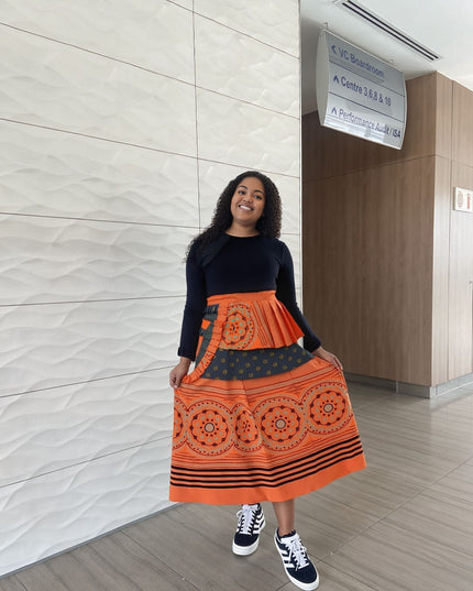 Printed high-waist skirt in orange-red with circular medallion print and striped hem