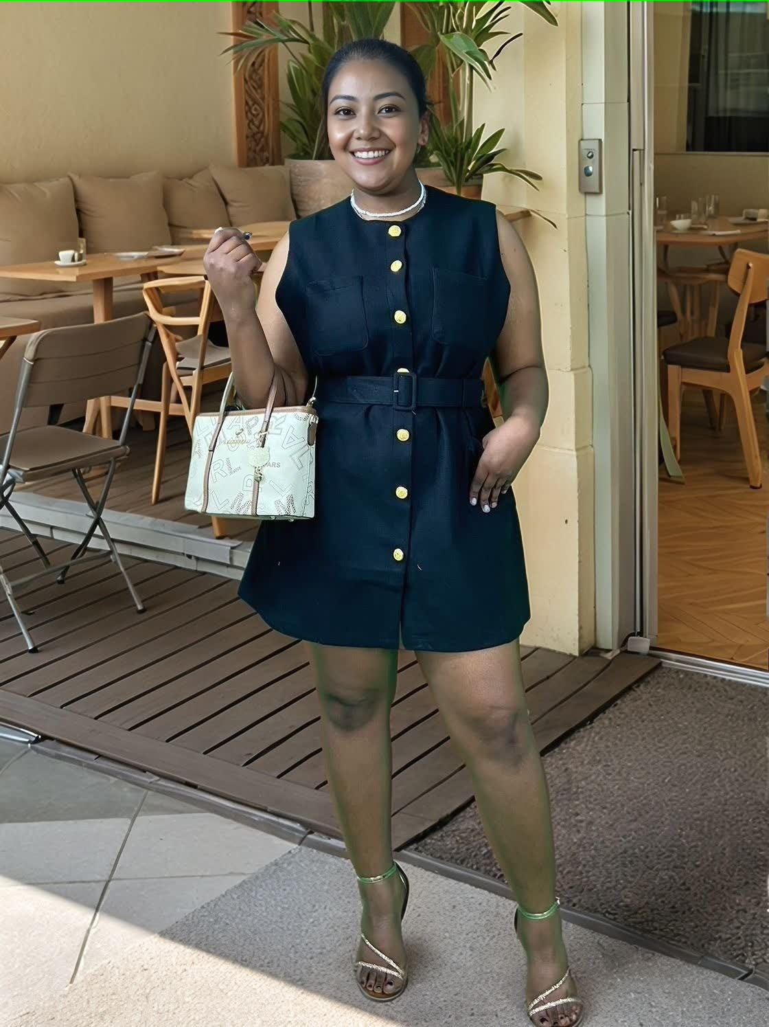 Black belted sleeveless mini dress with gold buttons and front pockets