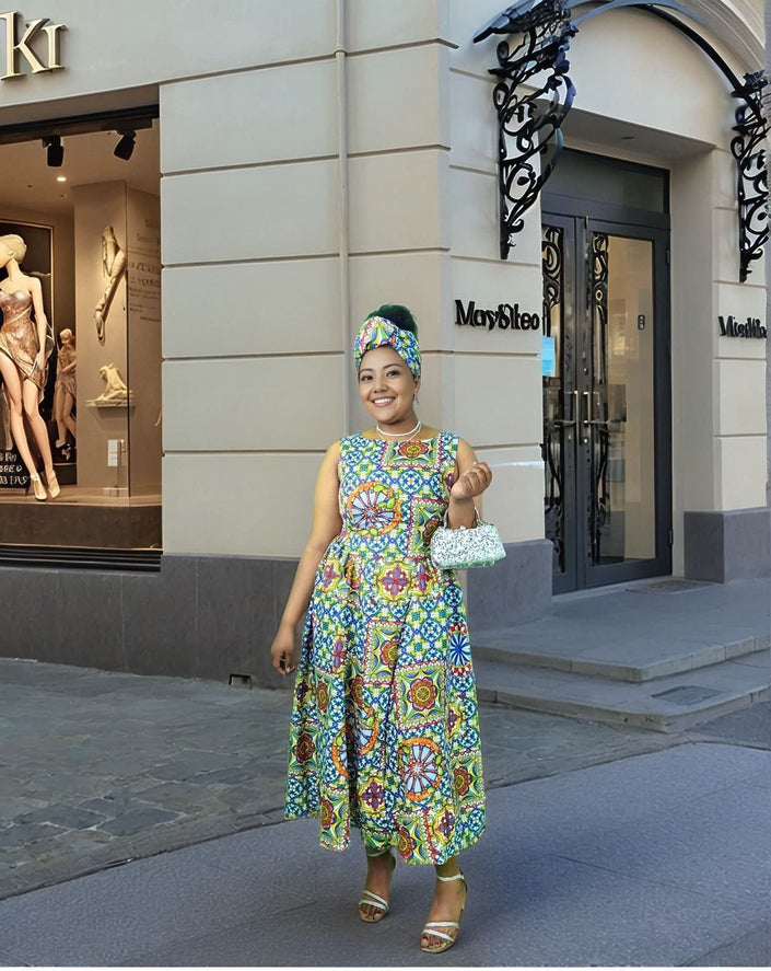 Sleeveless geometric print midi dress with colorful patterned skirt and fitted bodice