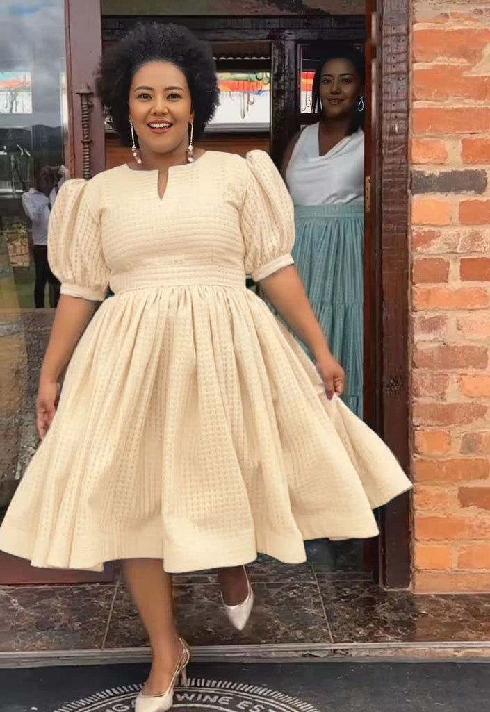 Wheat textured midi dress with puff sleeves and gathered waist, flared skirt.