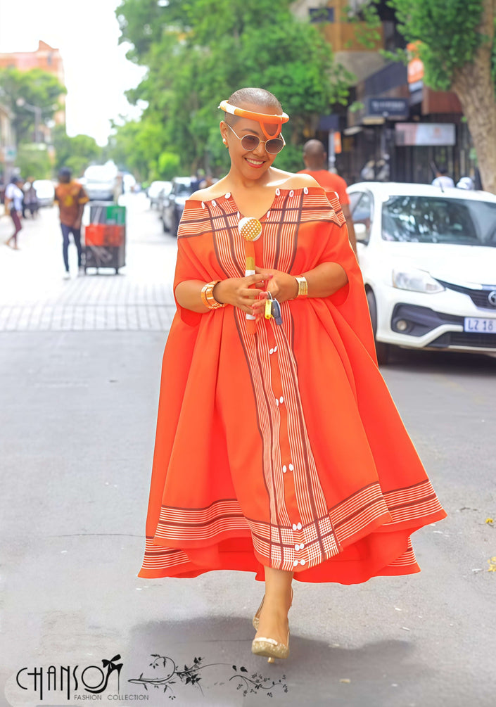 Orange-red maxi dress with cape sleeves, striped off-shoulder yoke and vertical panel