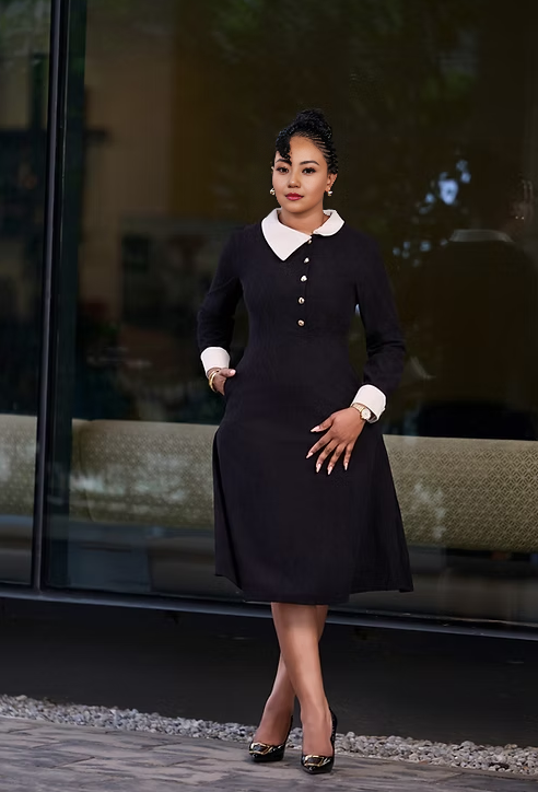Dark midi dress with white Peter Pan collar, long sleeves, and gold button front