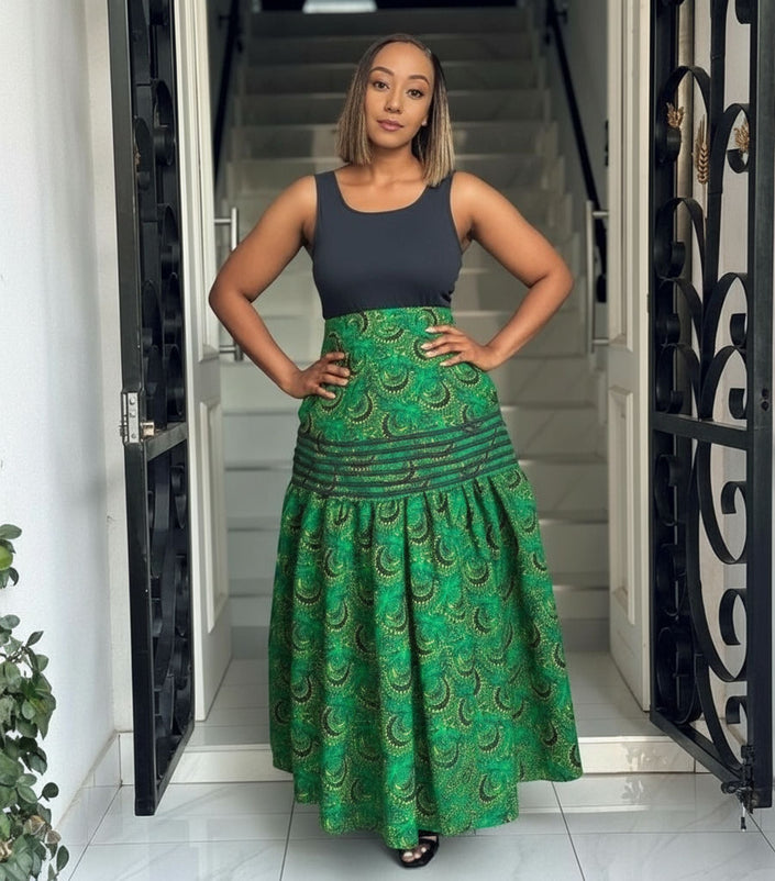 High-waist African print skirt, green with paisley pattern and tiered flare design.