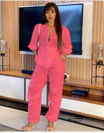 Hot-pink solid color jumpsuit with front placket and drawstring waist, long sleeves
