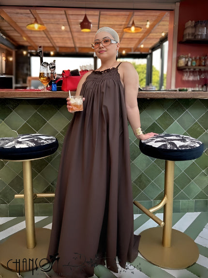 Dark sleeveless maxi dress with gathered neckline and billowy full-length skirt