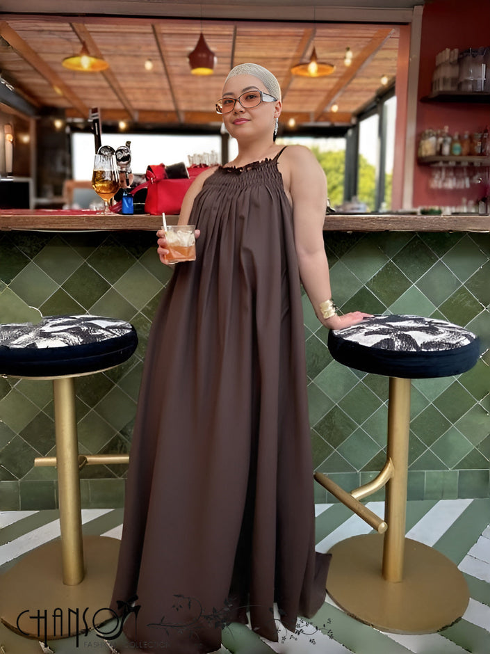Dark sleeveless maxi dress with gathered neckline and billowy full-length skirt