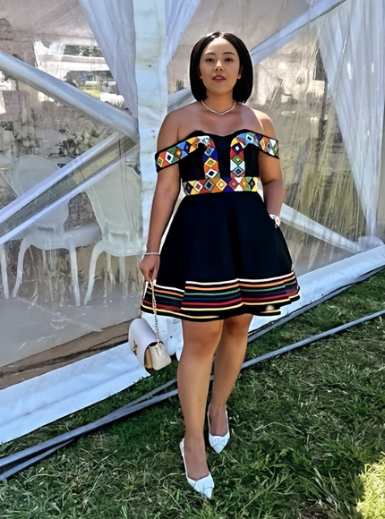 Off-shoulder mini dress with black bodice and multicolor patterned yoke, striped hem