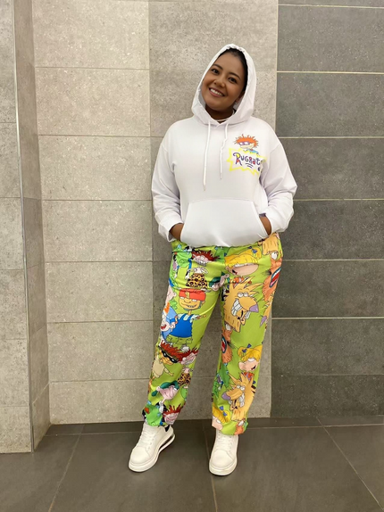 White cartoon hoodie set with green character-print pants, relaxed fit with cuffs.