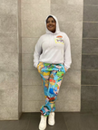 White cartoon hoodie set with blue character-print pants, relaxed jogger cuffs.