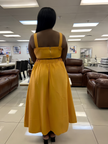 Back view of yellow sleeveless midi dress with pleated high waist and center back seam