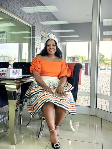 Off-shoulder ruffle dress with orange bodice and geometric print skirt